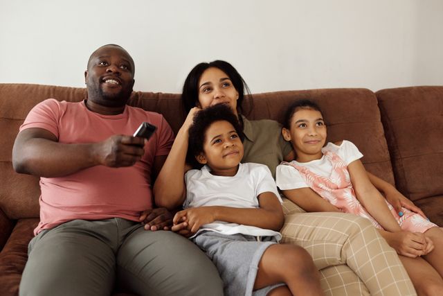 Family relaxing on a sofa watching a crisp, high-definition picture on their living room TV